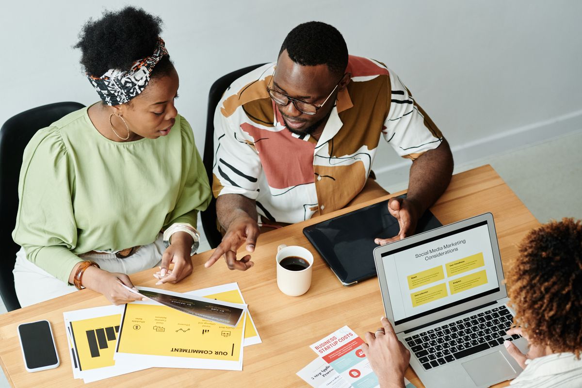 Team collaborating around a laptop in an office
